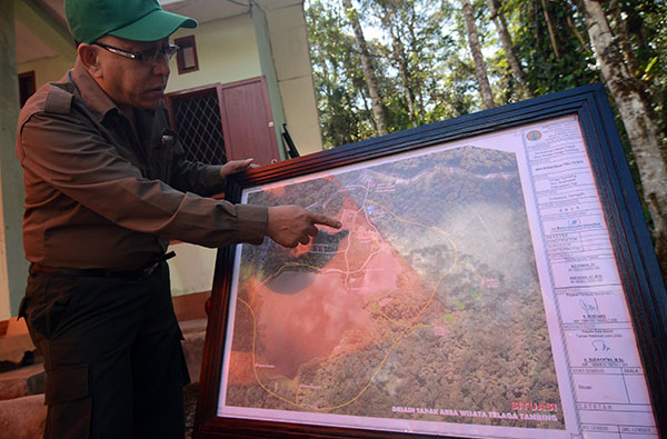 Kepala Balai Taman Nasional Lore Lindu (TNLL) Sudaryatna menunjukkan peta pengembangan kawasan eko wisata Telaga Tambing. Di kawasan ini akan dibanuna sejumlah fasilitas yang lebih memadai tetapi dengan tetap berpedoman pada kawasan lestari. (foto: bmzIMAGES/Basri Marzuki)