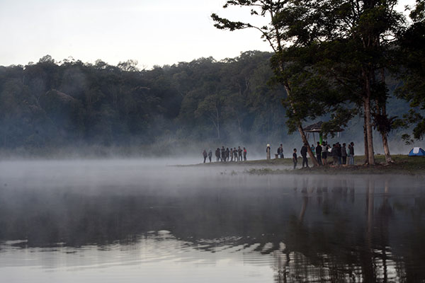 Sebagian pengunjung mulai tersadar akan suguhan panorama telaga di pagi hari yang sangat memikat dengan kabut yang memenuhi permukaan air telaga. (Foto: bmzIMAGES/Basri Marzuki)