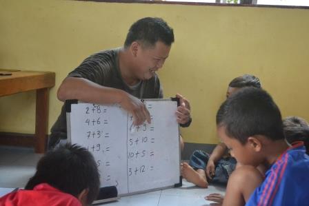 Relawan yang mengajari anak-anak 