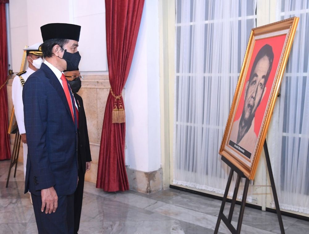 Presiden Jokowi memandangi potret Arnold Mononutu pada hari acara penganugerahan pahlawan nasional tahun 2020.