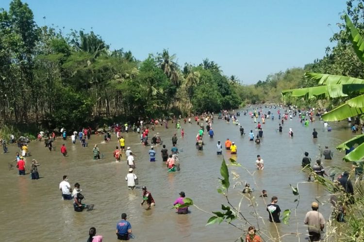 Warga berbondong berebut ikan di Sungai | Foto: Travel Kompas