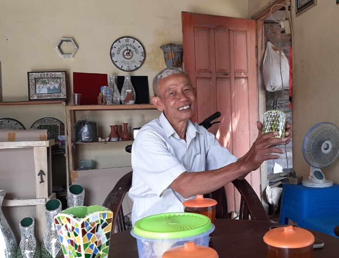 Suyanto (60) sedang menunjukkan salah satu hasil produk kerajinan kaca Surya Citra Mozaik