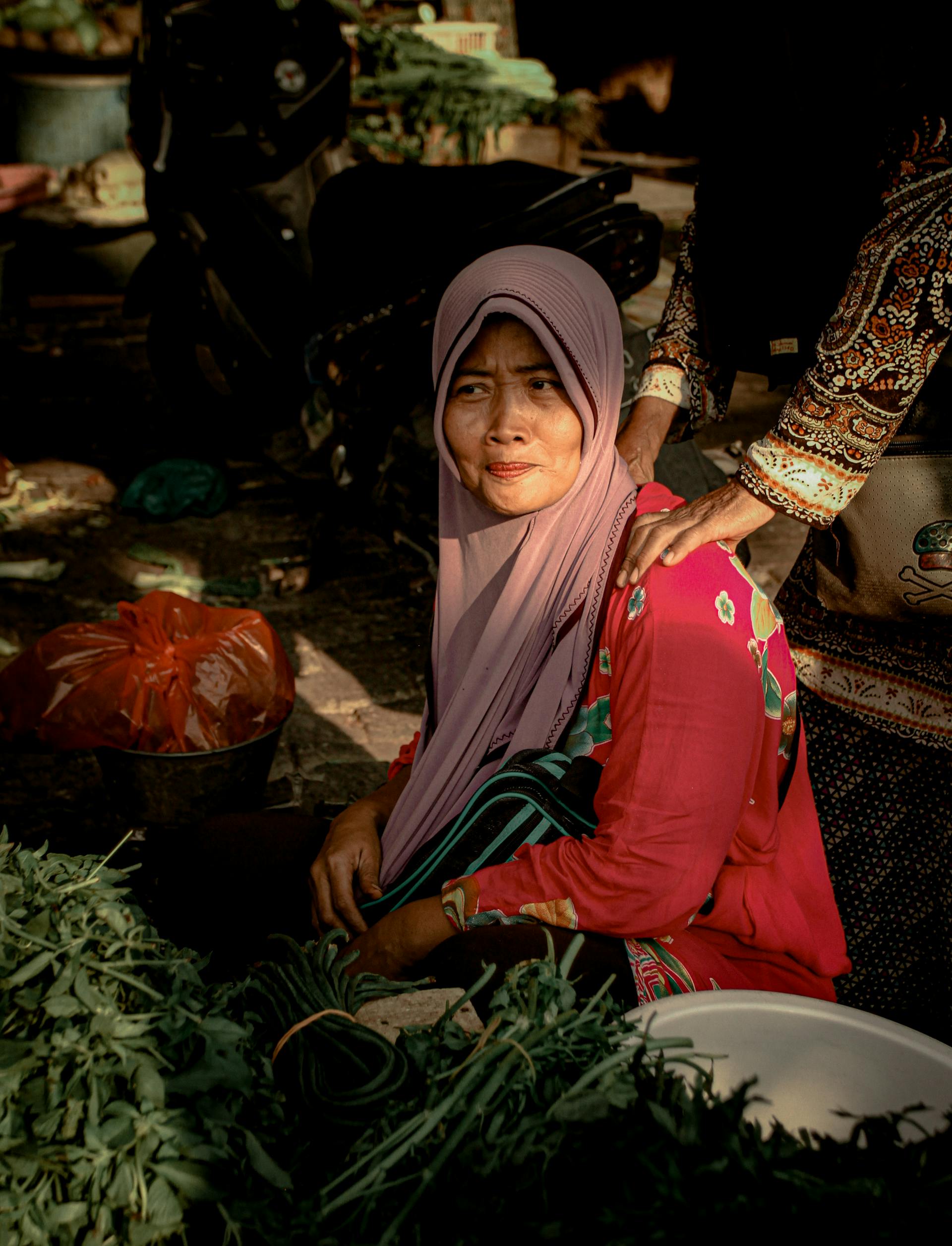 Foto oleh Ida Rizkha: https://www.pexels.com/id-id/foto/wanita-mengenakan-jilbab-merah-muda-di-pasar-menjual-sayuran-mendapat-pijat-bahu-3012422/