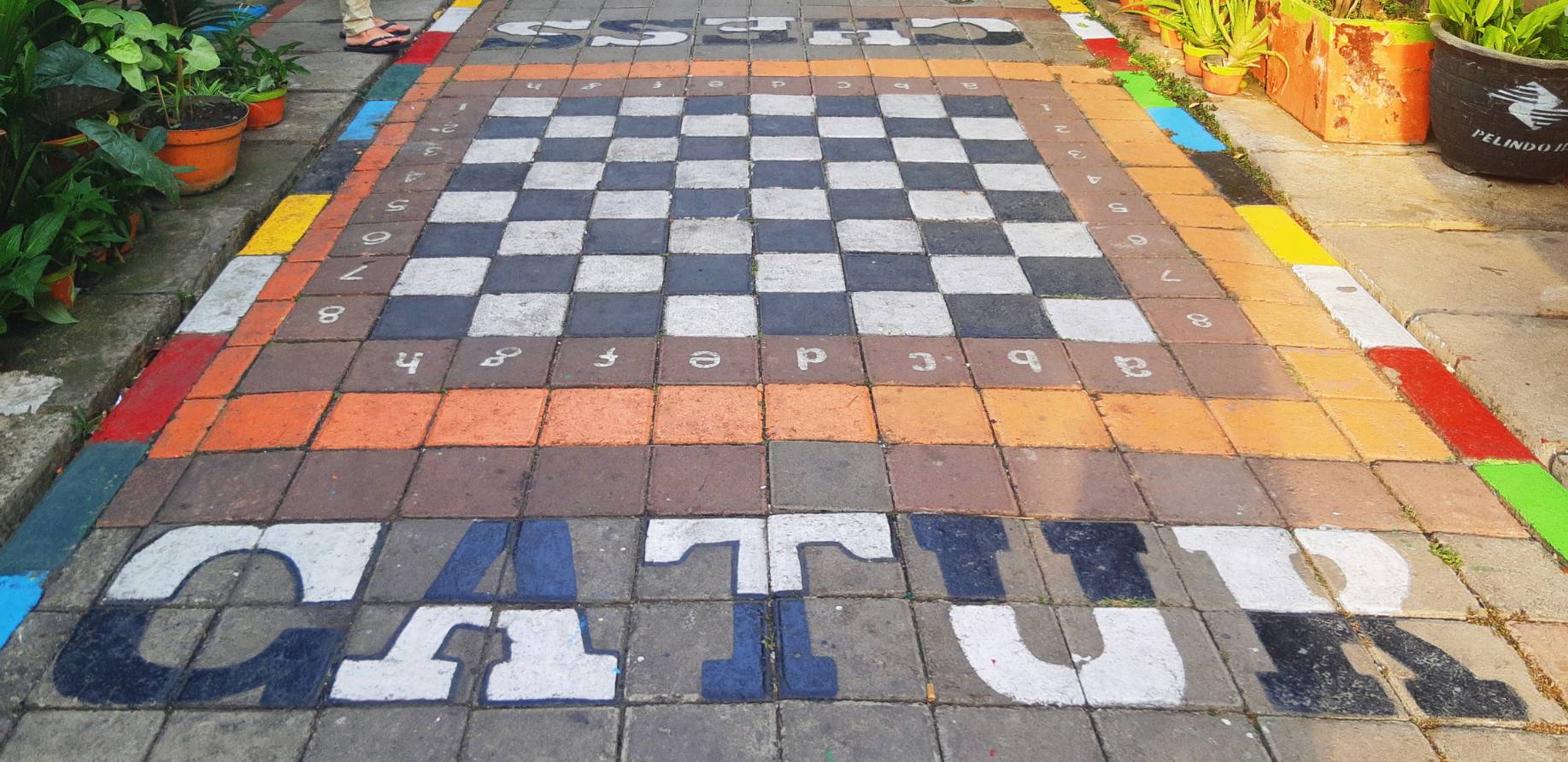 Sebuah papan permainan catur yang dibuat dalam bentuk lebih besar di lantai salah satu lorong di Kampung Lawas Maspati | Foto: Tara E.