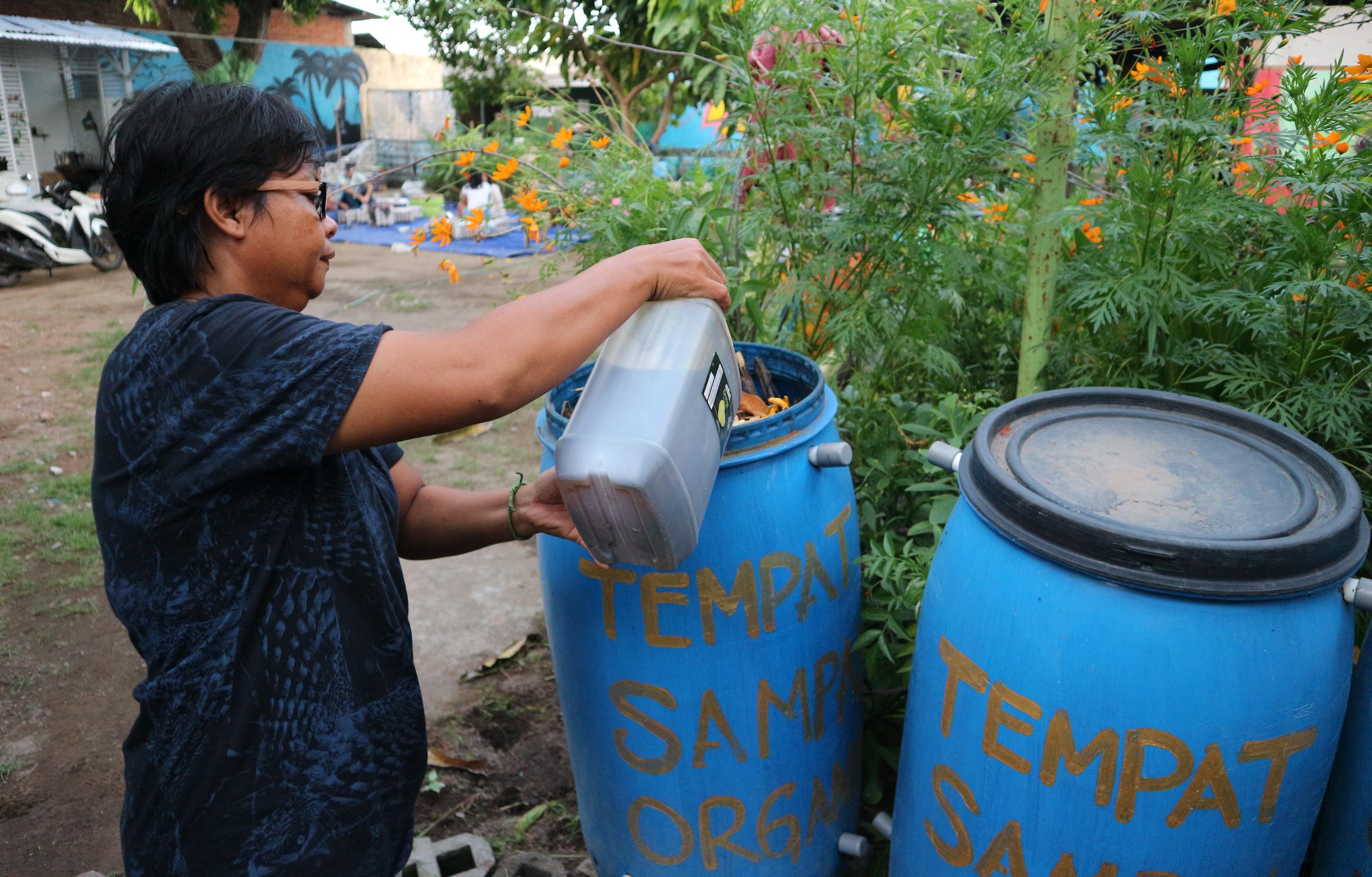  Siti Aisyah sedang mengontrol bak komposter pengolahan sampah organik di halaman rumahnya di Ampenan, Kota Mataram. Bak komposter ini banyak dipesan hotel dan kini mulai dipesan rumah tangga dan beberapa café di Mataram | Foto: Fathul Rakhman/Mongabay Indonesia 