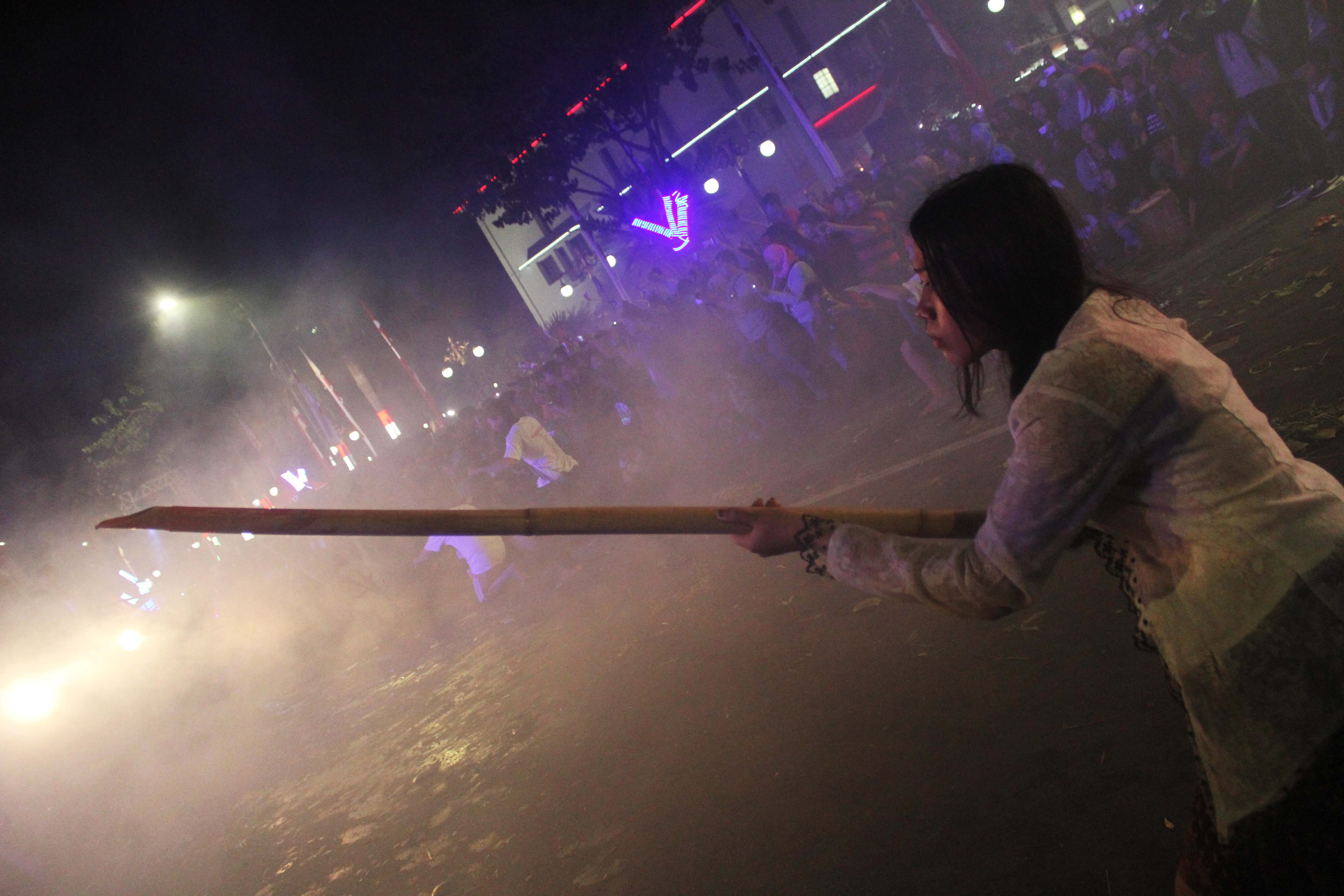 Pejuang mengacungkan senjata khas perjuangan yaitu bambu runcing