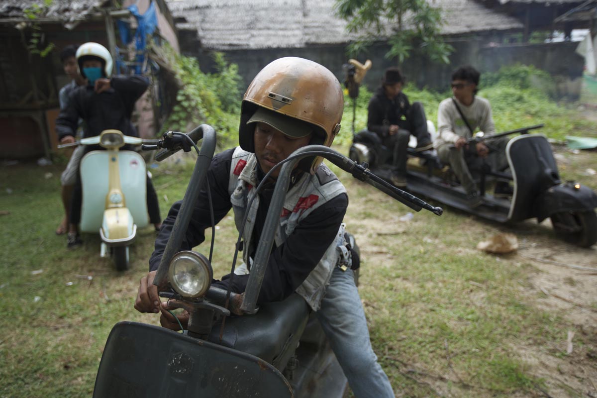 Penggemar Vespa mempersiapkan diri untuk kembali pulang dengan Vespa modifikasinya setelah festival skuter pada 30 Juni 2013 di Cibeureum, Indonesia sekitar 100 km barat Jakarta. (Ed Wray / Getty Images)