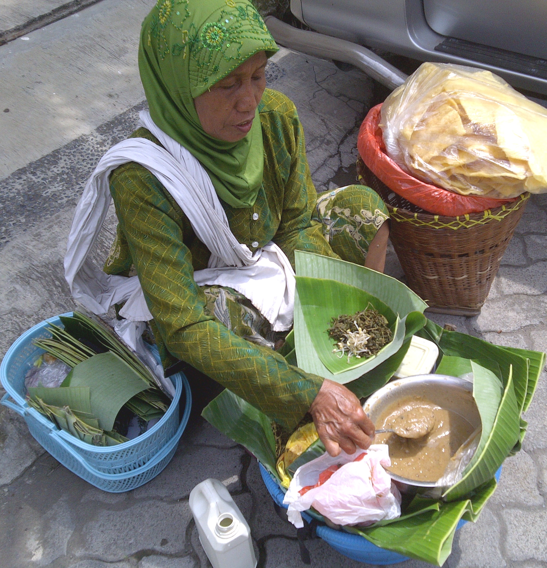 Ciri khas penjual pecel semanggi adalah menggunakan jarik atau selendang yang digunakan untuk menggendong seperangkat dagangan pecel semanggi. | Sumber Wikiwand